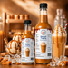 Caramel dessert topping bottles next to ice cream and thickshake, perfect for adding flavor to desserts.