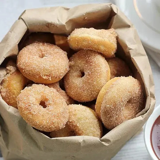 Classic Cake Donut Mix | World’s Best Tasting Donut Mix in a paper bag full of freshly made cinnamon donuts.