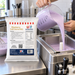 Blueberry Soft Serve 1KG bag beside mix being poured into a soft serve machine