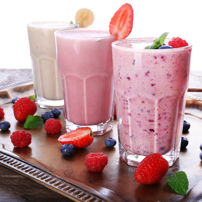 Delicious creamy smoothies in glasses, topped with fruits, perfect for a refreshing treat with caramel dessert topping.