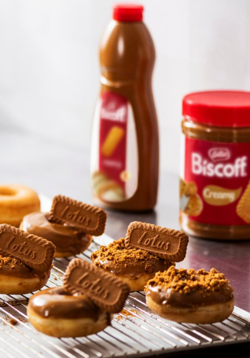 Lotus Biscoff spread 3kg donuts topped with Biscoff biscuits and crumbs on cooling rack in professional kitchen setting