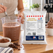 Whisking Premium Chocolate Soft Serve Mix in a measuring jug beside the 1kg pouch