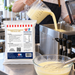 Pouring Pineapple Dole Inspired Soft Serve Mix into a soft serve machine beside the 1kg pouch