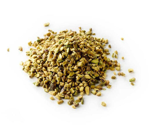 raw crushed pistachios bulk piled on white background, vibrant green crunchy pistachio pieces for baking and dessert toppings